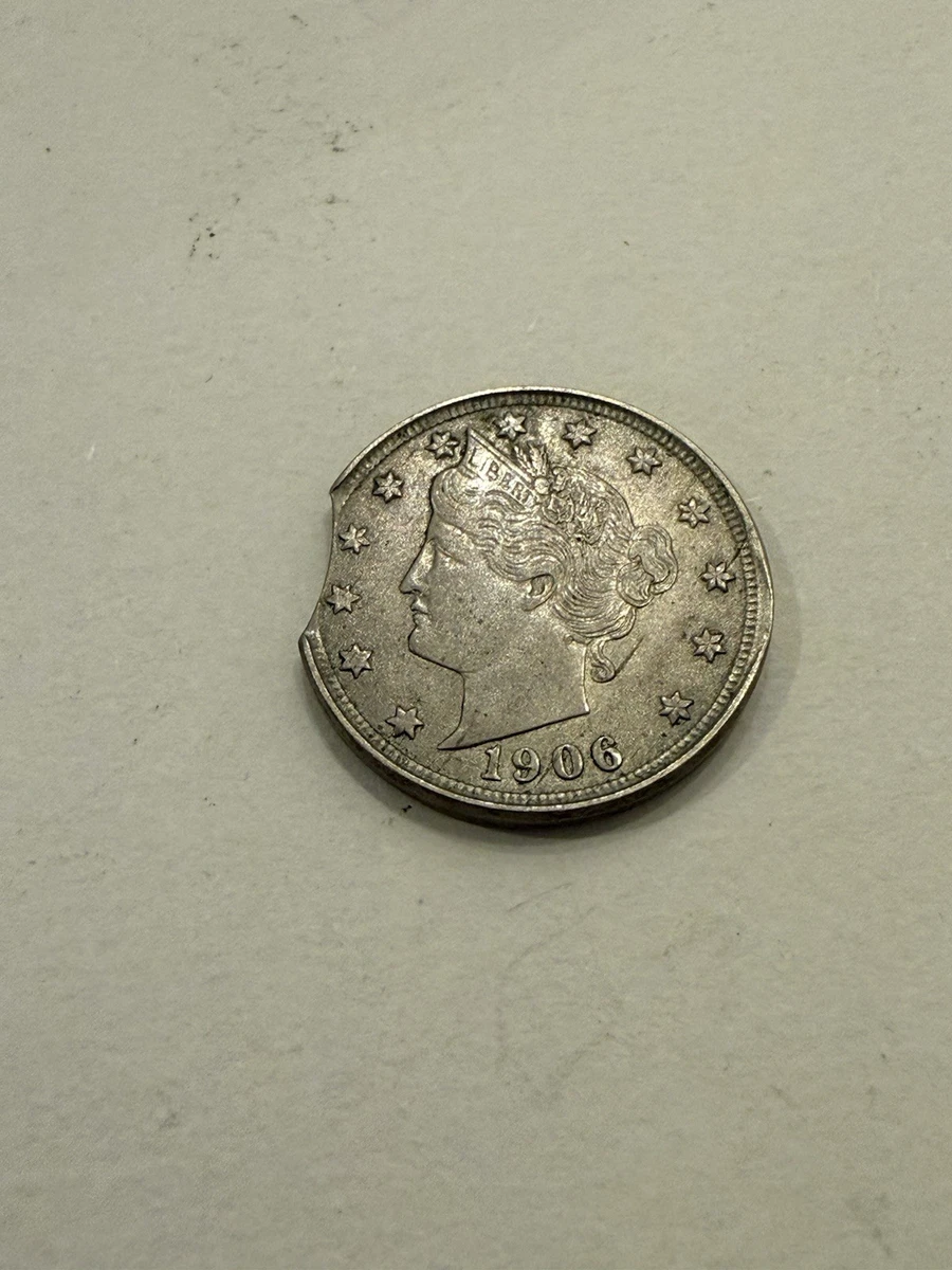 1906 Liberty Head Nickel with a curved clipped planchet showing a missing section of the rim edge where the blank punch overlapped a previously punched hole during planchet cutting